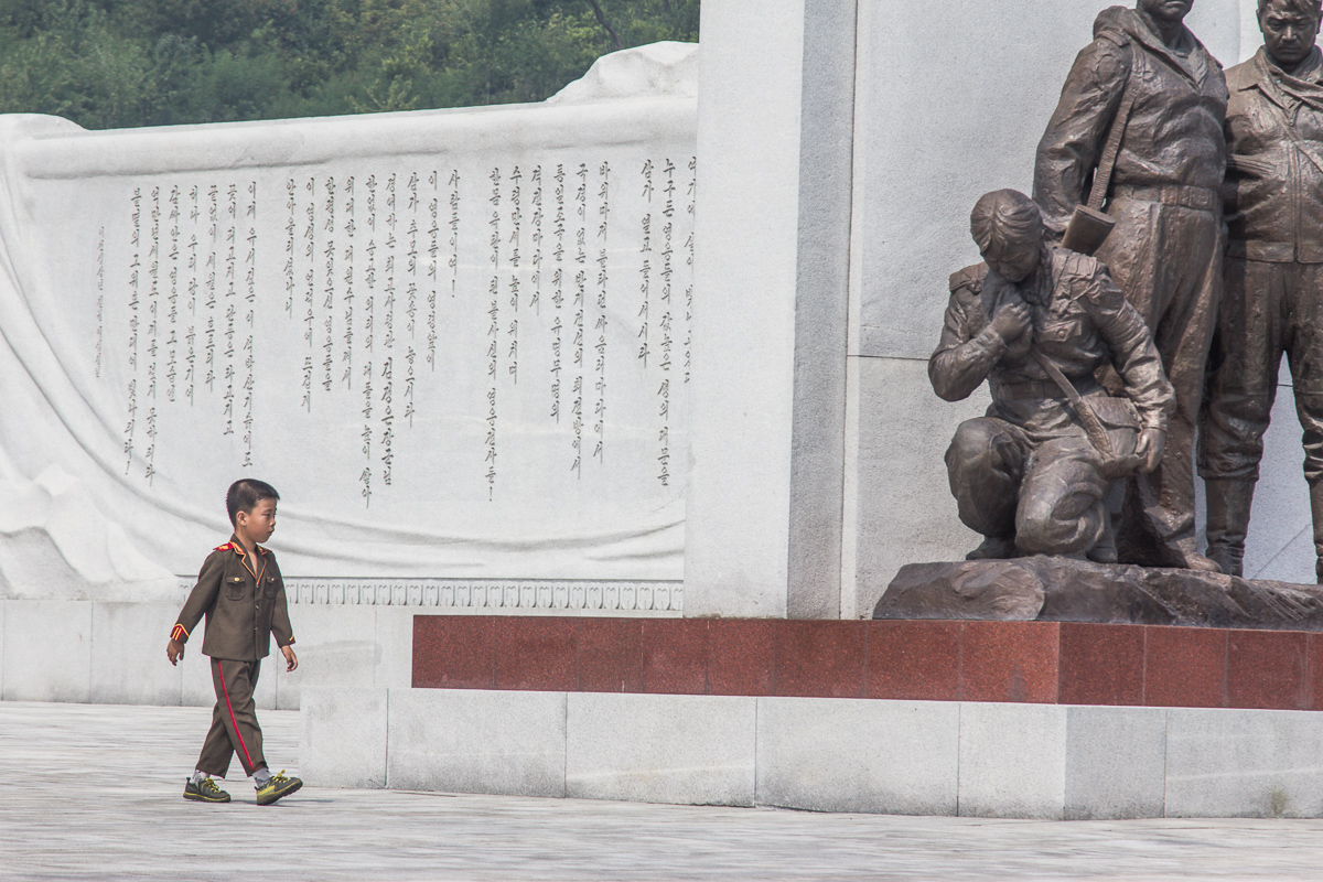 Jongetje bij een monument ter nagedachtenis van de vaderland bevrijdingsoorlog